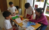 ボランティア（右）が開催した日本祭りで参加者に折り紙を教えている様子